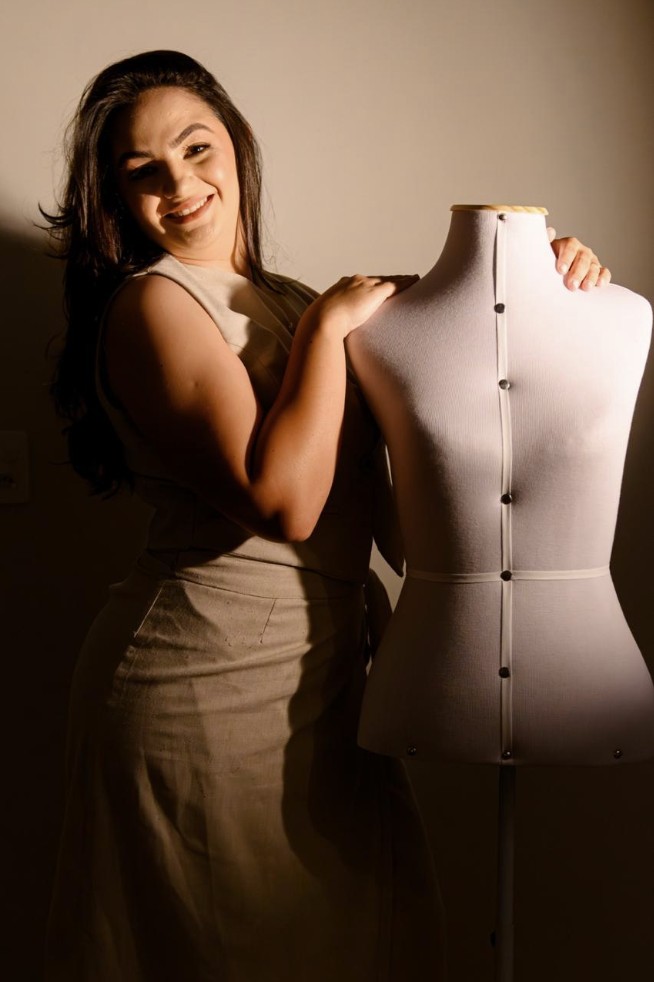 A costureira ao lado do manequim de modelagem, em luz lateral